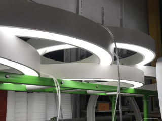 A series of ring shaped LED pendant lights with an LED strip.
